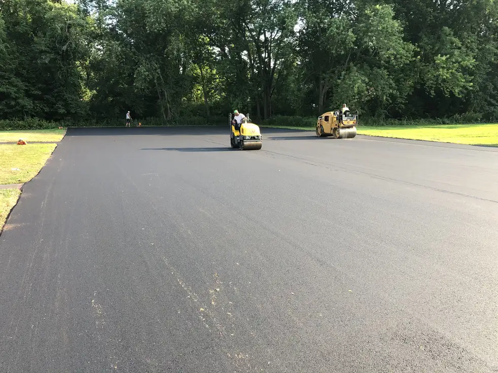 Two rollers compacting new asphalt across a large parking lot in Salem, NH, Young's Excavating & Paving LLC, 37 Washington St, Penacook, NH.