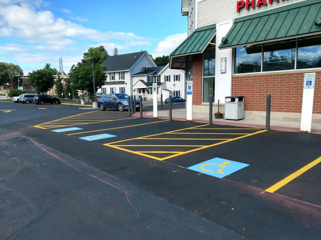 Accessible parking spaces with adjacent striped access aisles outside a commercial building.