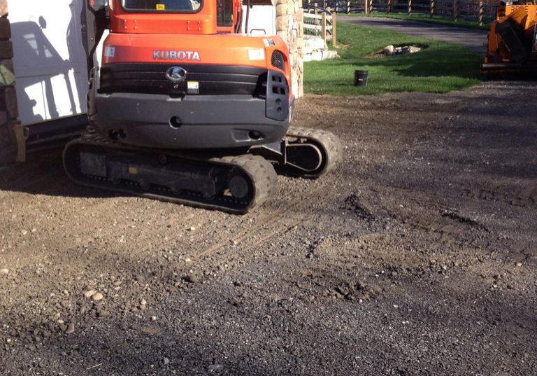 Mini excavator working on a residential driveway excavation, Young's Excavating & Paving LLC, Penacook, New Hampshire.